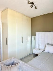 um quarto com armários brancos e uma cama em CBD Studio Apartment em Windhoek