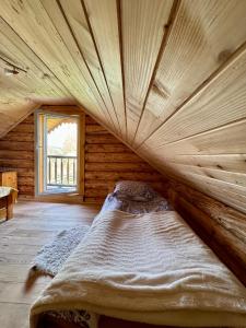 Cama grande en habitación con techo de madera en Cichy Zakątek u Basi 