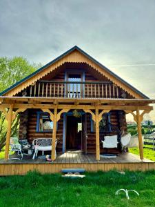 a log cabin with a porch and a deck at Cichy Zakątek u Basi 