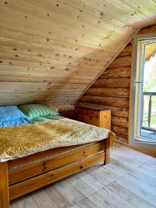 1 dormitorio con 1 cama en una cabaña de madera en Cichy Zakątek u Basi 
