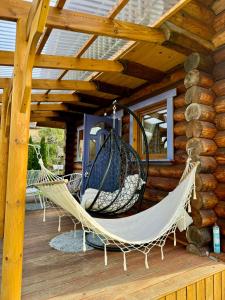 a porch with two hammocks on a log cabin at Cichy Zakątek u Basi 