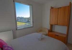 a bedroom with a white bed and a window at Appartement 97m2-Roof Top privé 100m2-Parking privé-Clim mobile in Nantes