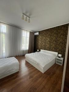 una camera con due letti e una parete di House of Tourists Garden and More a Bucarest