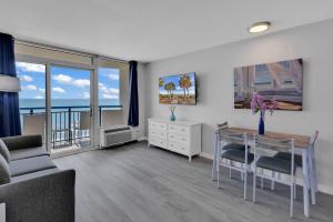 een woonkamer met een tafel en uitzicht op de oceaan bij Boardwalk Resort: Ocean Breeze Retreat in Myrtle Beach