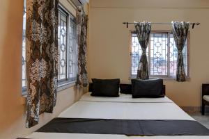 een bed in een kamer met 2 ramen bij OYO Florence Guest House And Home Stay in Calcutta