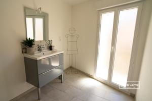 a bathroom with a sink and a mirror at Sublime Loft de 130m climatisé au calme in Vias