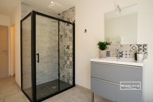 a shower with a glass door in a bathroom at Sublime Loft de 130m climatisé au calme in Vias