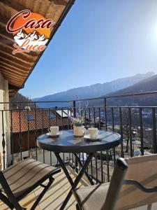 een tafel en stoelen op een balkon met uitzicht bij Casa Luca in Mezzana