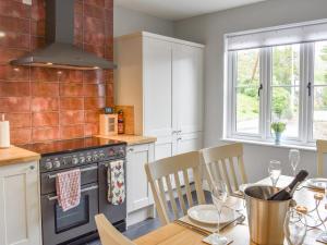 a kitchen with a table and a stove top oven at Fairholme in Bodfari