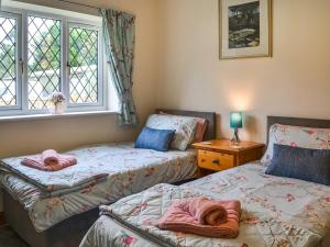 two beds in a room with a window at Heatherdene - Fern Cottage in Wilberfoss