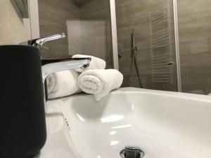 a white bathroom with towels on a sink at Casa Luca in Mezzana +22 photos