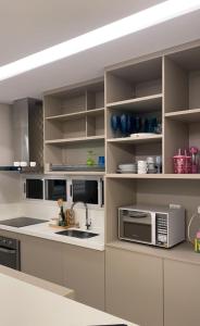 a kitchen with a sink and a microwave at Casa para Carnaval in Recife