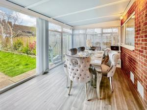 - une salle à manger avec une table, des chaises et des fenêtres dans l'établissement Sunrise Villa, à Clacton-on-Sea