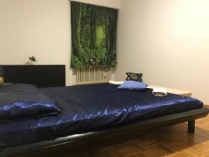 a bedroom with a large blue bed with a window at Pregassona Relaxing Home in Lugano