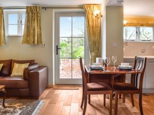 a living room with a table and chairs and a couch at The Coach House Annexe in Tilston