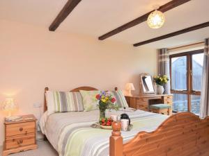 um quarto com uma cama com um vaso de flores em 3 bed in Bude 00597 em Warbstow