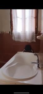ein weißes Waschbecken im Bad mit Fenster in der Unterkunft Sousou2 in Skikda