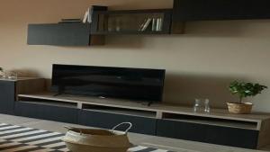 un soggiorno con TV a schermo piatto su un centro di intrattenimento di Lepanto House Positano a Positano
