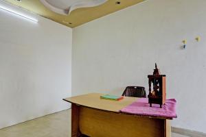- un bureau dans une chambre avec un tissu rose dans l'établissement SPOT ON Arise Hotel, à Saharanpur