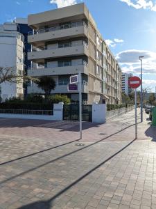 ein Straßenschild vor einem Gebäude in der Unterkunft Apartamento Los Juncos - 50m playa - Sólo familias - Parking gratuito - WIFI - TV 55" 4K - PS5 in Playa de Gandia