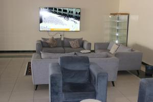 فندق سرر المحمديه الرياض في الرياض: غرفة معيشة مع أريكة وكرسيين