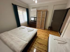 a bedroom with two beds and a mirror in it at Palm Konak Hotel in Cıralı