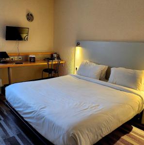 een groot wit bed in een hotelkamer bij The Originals City, Hôtel Le Forum, Strasbourg Nord in Schiltigheim
