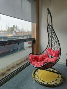 a swing chair sitting in front of a window at Uusi kaksio parvekkeella ja autopaikalla in Joensuu