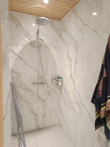 a bathroom with a shower with a marble wall at Uusi kaksio parvekkeella ja autopaikalla in Joensuu