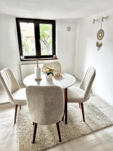 a dining room with a white table and chairs at Home central apartment Sibiu in Sibiu +27 photos