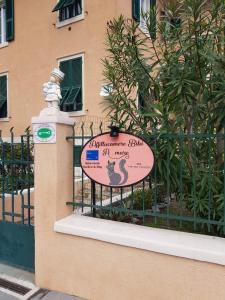 un panneau sur une clôture devant un bâtiment dans l'établissement Bibi a Mare, à Finale Ligure