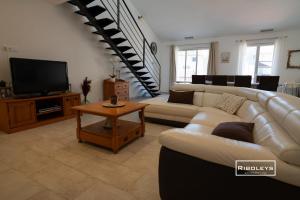 a living room with a couch and a tv at Sublime Loft de 130m climatisé au calme in Vias