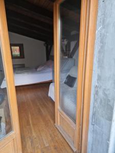 une porte en verre menant à une chambre avec un lit dans l'établissement Chambre d'hôtes Lovagny, à Lovagny