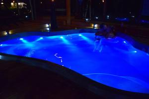 a blue hot tub with a person in it at night at Footprints Resort in Bancroft
