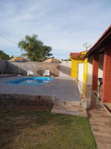 een klein zwembad in een tuin naast een huis bij Casa com piscina in Andirá