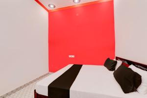 Camera rossa con letto a parete rossa. di OYO Hotel sadhna Palace 