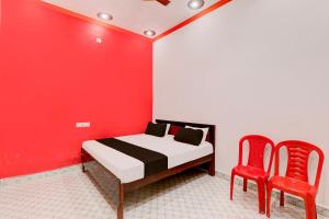 una camera con un letto e due sedie rosse di OYO Hotel sadhna Palace 