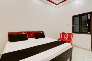 una camera con un letto e due sedie rosse di OYO Hotel sadhna Palace 