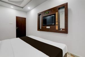 a bedroom with a bed and a tv on the wall at Collection O Star Inn Hotel in Lucknow