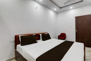 a bedroom with a bed and a red chair at Collection O Star Inn Hotel in Lucknow