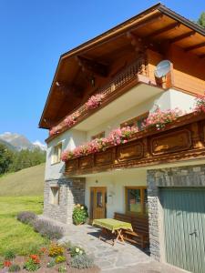 a house with flowers on the side of it at Ferienhaus Alpenblick in Heiligenblut