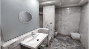 y baño con lavabo, aseo y espejo. en Almansour Hotel en Bagdad