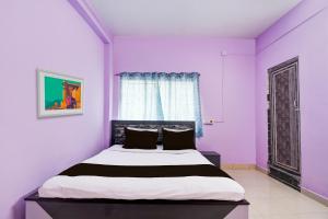 - une chambre avec des murs violets et un lit dans l'établissement SPOT ON Hotel Sunshine Lodging, à Āsansol