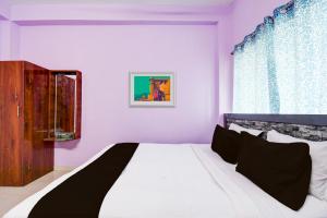 - une chambre avec un lit blanc et une fenêtre dans l'établissement SPOT ON Hotel Sunshine Lodging, à Āsansol