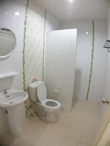 a white bathroom with a toilet and a sink at House in community mall, spacious 6 people, 3BR in Chiang Mai