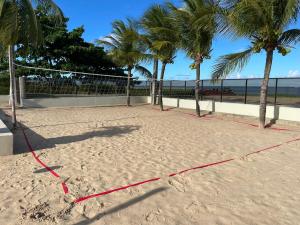 a volleyball court on the beach with palm trees at Casa à Beira-mar de Peroba in Peroba