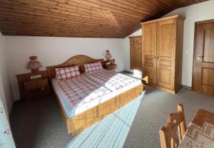 - une chambre avec un grand lit et un plafond en bois dans l'établissement Ferienhaus Alpenblick, à Heiligenblut