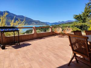 a patio with a table and two chairs and a table and a table at Le Panoramique du Plongeoir - T4 spacieux de 90m2 avec grande terrasse vue sur le lac de Serre Ponçon in Savines