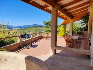 a patio with a table and chairs and a grill at Le Panoramique du Plongeoir - T4 spacieux de 90m2 avec grande terrasse vue sur le lac de Serre Ponçon in Savines