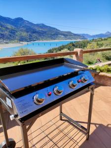 a barbecue grill on a deck with a view of a river at Le Panoramique du Plongeoir - T4 spacieux de 90m2 avec grande terrasse vue sur le lac de Serre Ponçon in Savines +41 photos